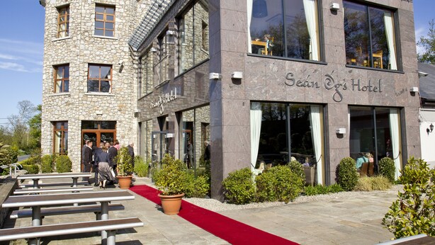 A hotel with a stone facade and a red carpet leading to the entrance. - Upton Court Holiday Cottages (Kilmuckridge)