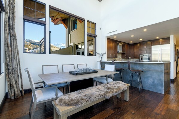 A modern kitchen with dark wood cabinets, stainless steel appliances, and a large island with bar stools.