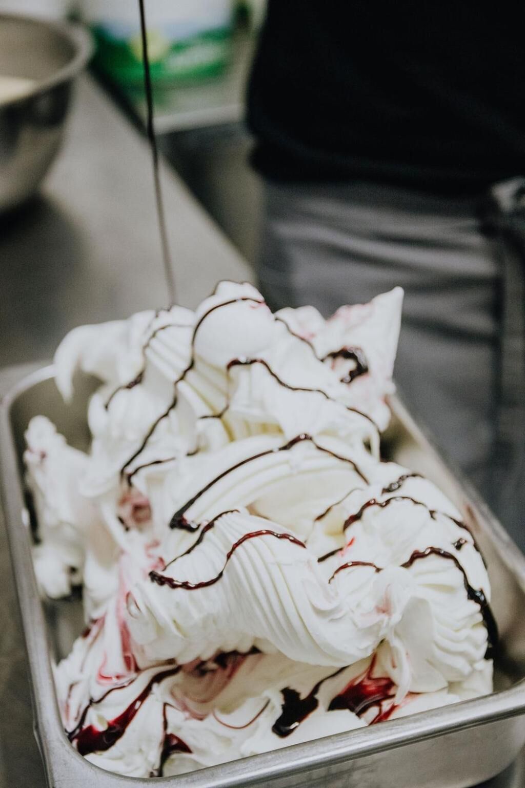 Una bandeja de helado con crema batida y salsa de chocolate.