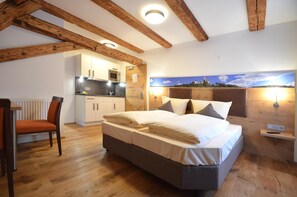 A bedroom with a bed, a chair, a nightstand, a wall-mounted lamp, and a view of the sky. - BAUER Gästezimmer (Kipfenberg)