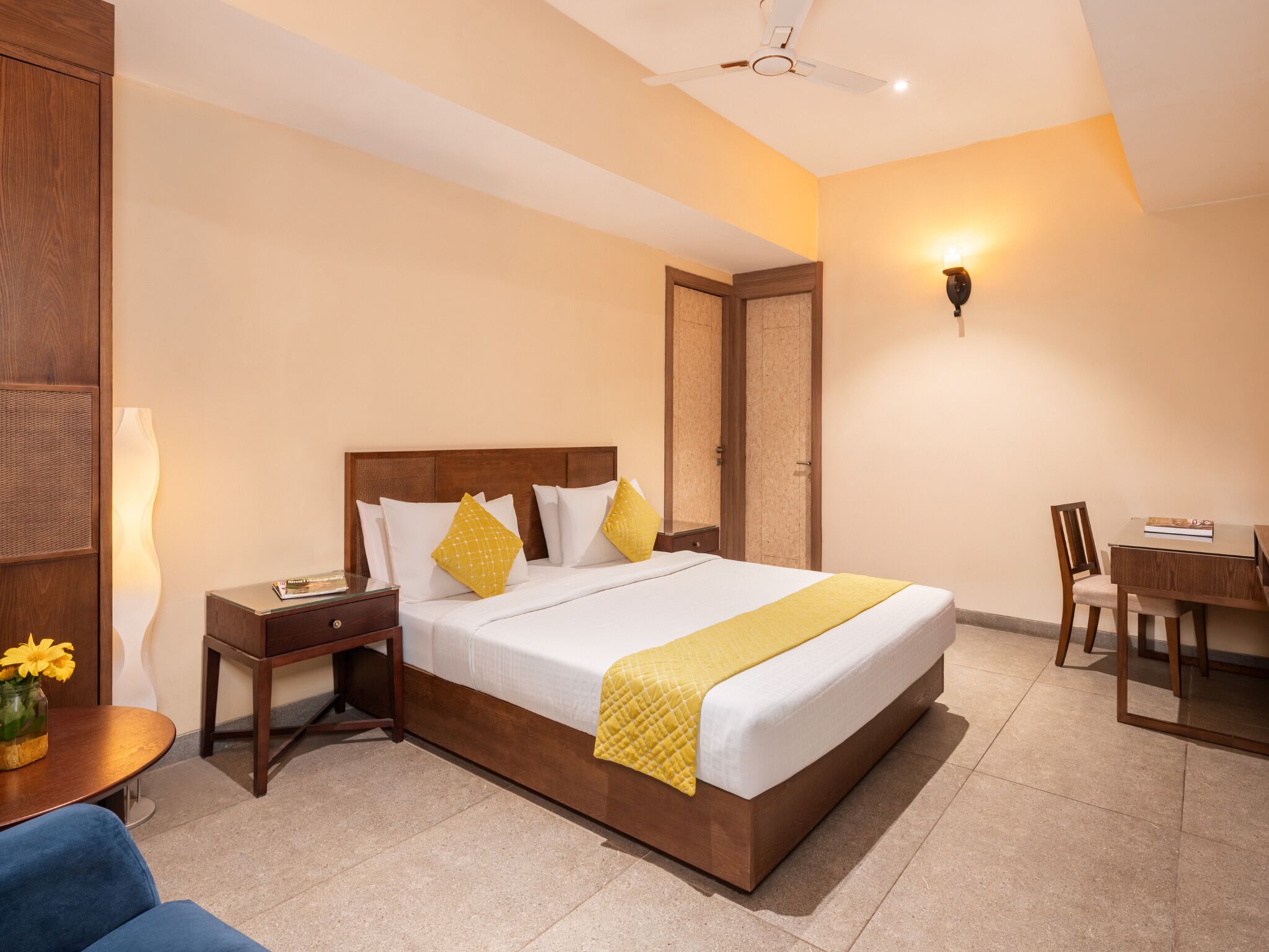 Une chambre d’hôtel avec un grand lit, des tables de chevet, un bureau et une chaise.