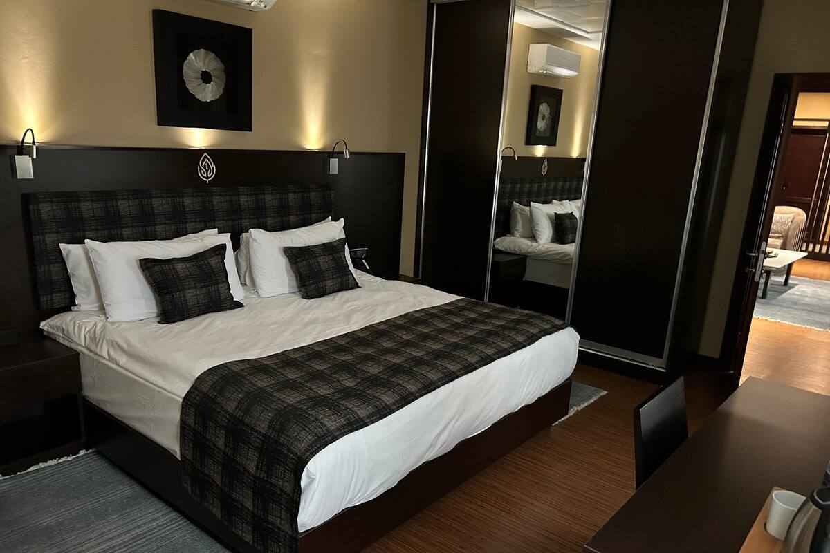 Une chambre d’hôtel moderne avec un grand lit, un bureau et un miroir.