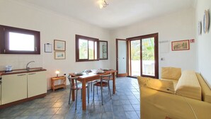 Un espace de vie compact comprenant un coin repas, une kitchenette et un canapé.