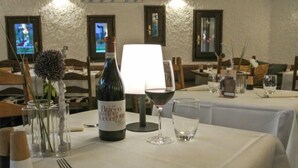 A dining table set with a bottle of Brico del'Occellone wine, a wine glass, a water glass, and cutlery. - Residenza Chesa Margun 13-4 by Interhome (Silvaplana-Surlej)