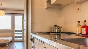 A modern kitchen with a stainless steel stove, a pot on the counter, and two bottles of hand soap. - Valaisia 35A by Interhome (Nendaz)