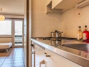 Een koelkast, een magnetron, kookgerei, borden en bestek