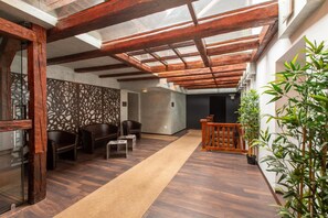 Un interior espacioso con techo de madera, pared con diseño y una alfombra beige larga.