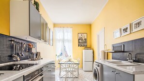 Een kleine keuken met een eethoek, een wasmachine en een koelkast.