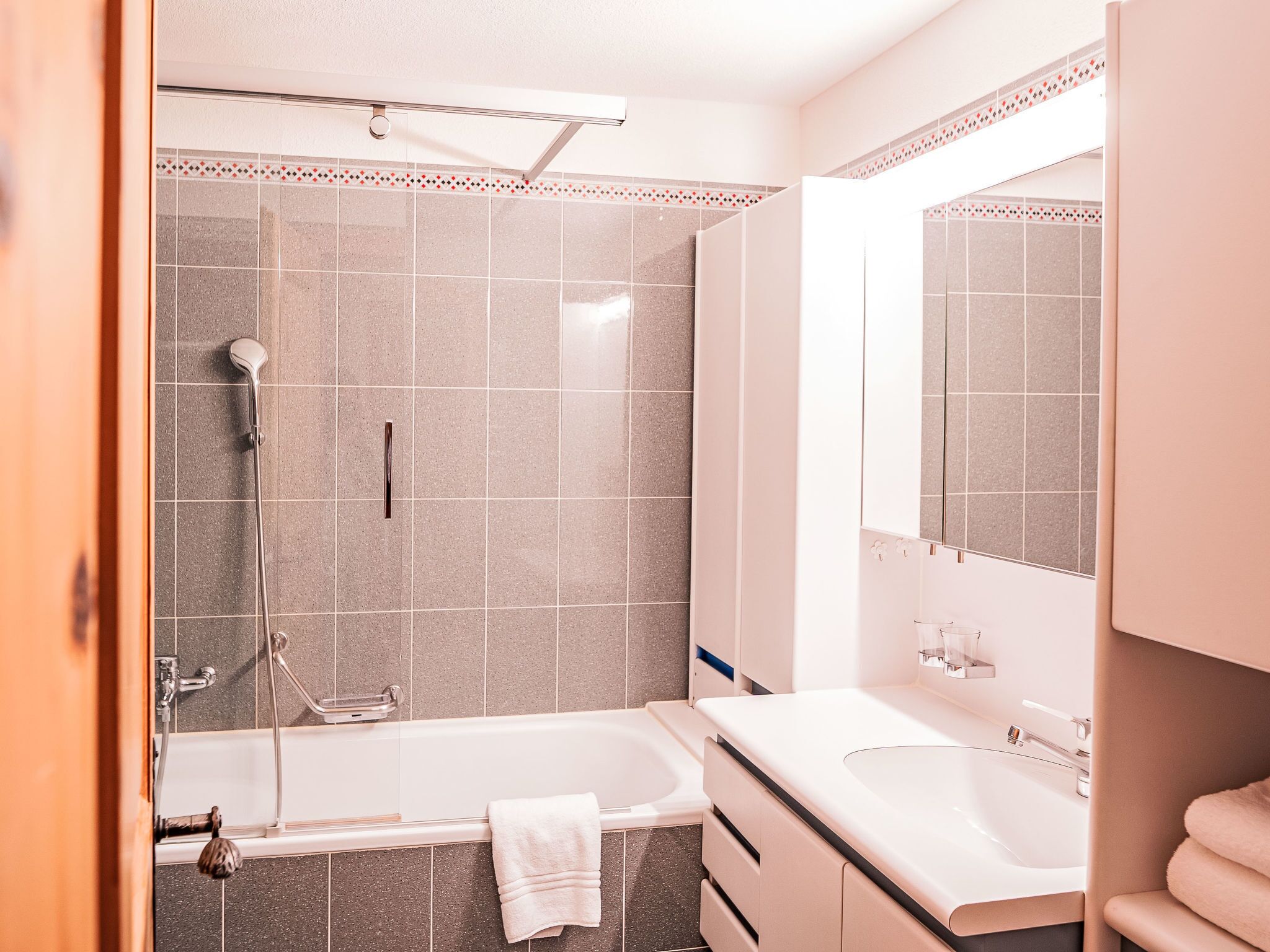 A modern bathroom with a bathtub, a shower, and a sink.