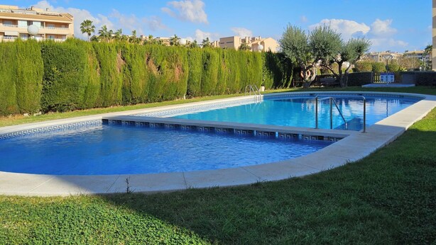 A swimming pool with a geometric tile pattern, surrounded by well-maintained grass and hedges. - Celio I by Interhome (Albir)