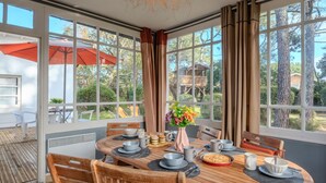 Un comedor con una mesa redonda de madera, sillas y vistas al exterior.