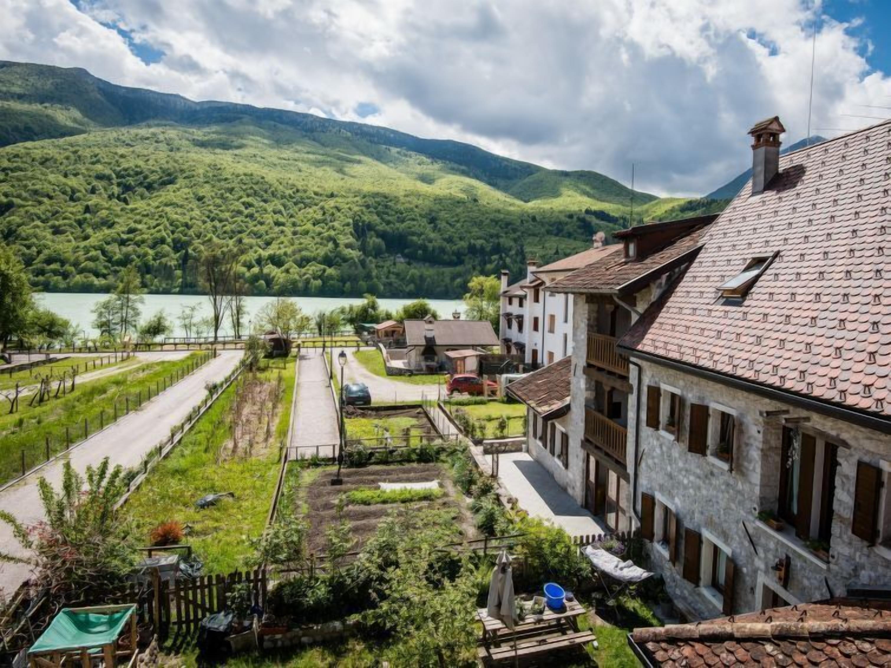 A residential area with terraced houses, a garden, and a lake in the background.