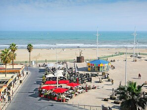 A beachside café with outdoor seating and a colorful kiosk. - Le Régent by Interhome (Canet-Plage)