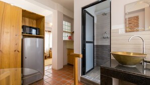 A modern bathroom with a large sink, a wooden cabinet, and a glass shower enclosure. - Team Yala Inn (Lalitpur)