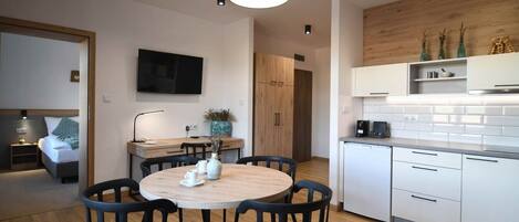 A modern kitchen with white cabinets, a wooden countertop, and a built-in oven.