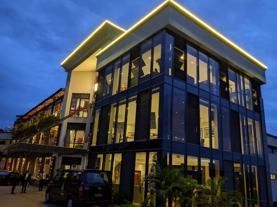 A modern hotel with a glass facade, multiple floors, and a prominent entrance with a staircase.