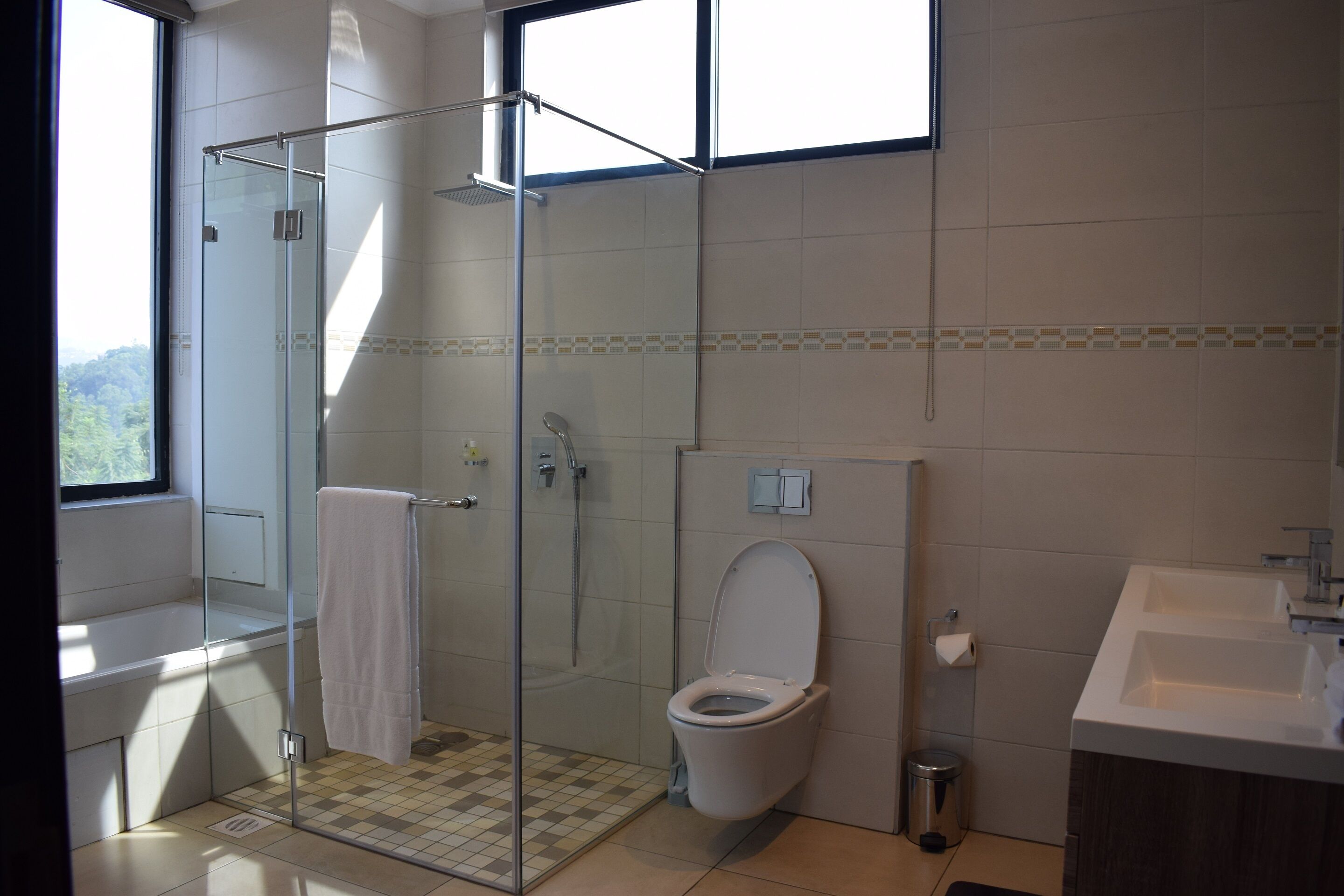 A modern bathroom with a glass-enclosed shower, a toilet, and a sink.