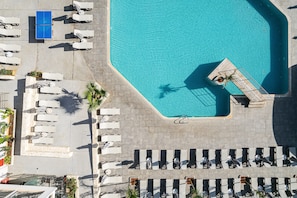 Vue aérienne d’une piscine, de transats et d’une petite zone aménagée pour se détendre.