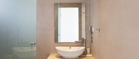 Une salle de bain avec un lavabo blanc, un miroir et une douche.