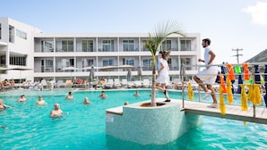 A swimming pool area with multiple levels of balconies, lounge chairs, and umbrellas. - Atali Grand Resort (Mylopotamos)