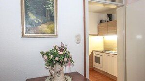 A kitchen with wooden cabinets, a sink, and a countertop. - Am Birkenhain by Interhome (Seefeld in Tirol)