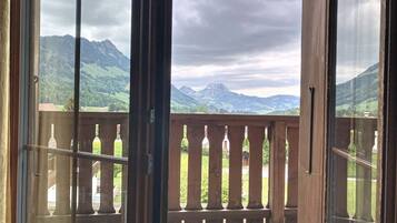 A balcony with a view of mountains and a cloudy sky.