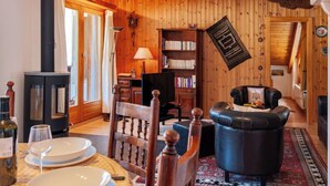 Un accogliente soggiorno con camino, pareti in legno, una libreria e un divano in pelle.