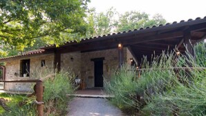 Un edificio rústico de piedra con un camino de grava que lleva a una puerta de madera.