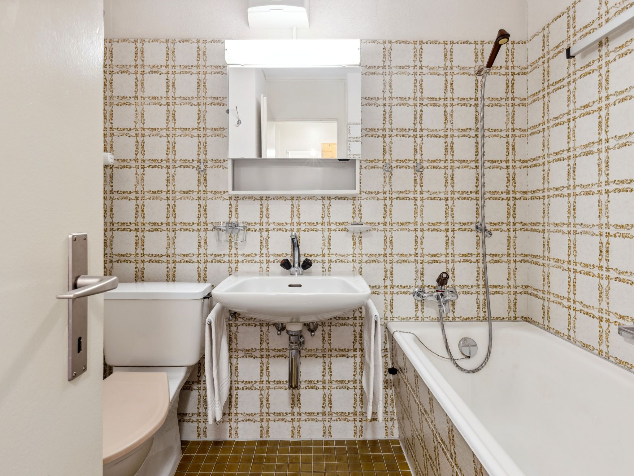 A bathroom with a toilet, sink, and bathtub, all with white fixtures.