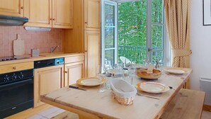 A kitchen with wooden cabinets, a Bosch dishwasher, a Bosch oven, and a large window with a view of greenery.