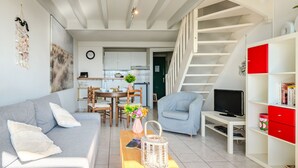 Een moderne woonkamer met een grijze bank, een houten salontafel en een tv-meubel.