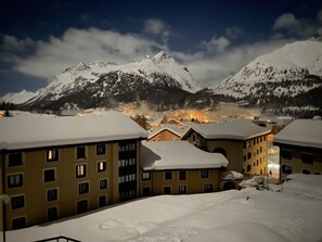 Et sneklædt bjerglandskab med bygninger i forgrunden.