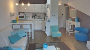 Un appartement moderne comprenant une cuisine, un coin repas et un salon.
