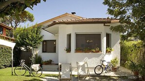 A house with a tiled roof, a front porch, and a gravel driveway. There are two bicycles parked outside. - Vacation home Sandra by Interhome (Forte dei Marmi)