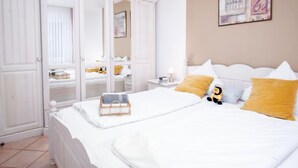 Une chambre à coucher avec un grand lit, une armoire et une table de chevet avec une lampe.