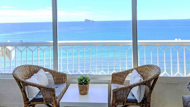 A balcony with wicker chairs, a small table, and a potted plant. - Torre Principado by Interhome (Benidorm)