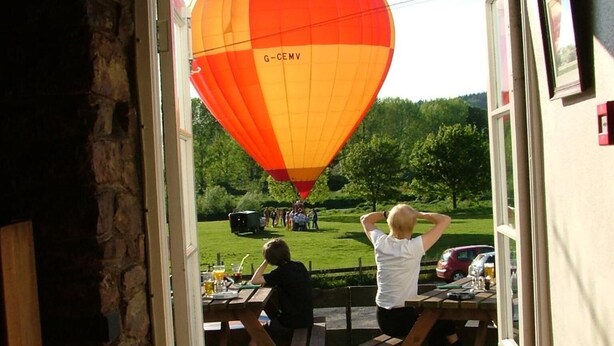 An entrance to a building with a view of a hot air balloon in the background.