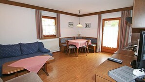 Una habitación acogedora con sofá, mesa de comedor y zona de kitchenette.