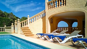 A pool area with lounge chairs, a staircase, and a view of the sea. - Villa Bellevue by Interhome (Jávea)
