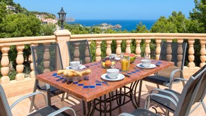 A dining table with chairs, a view of the sea, and a lamp. - Villa Bellevue by Interhome (Jávea)