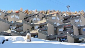 A multi-story hotel with a modern architectural design, featuring balconies and a ski slope in the background. - Residenz Surlej 6 by Interhome (St. Moritz)