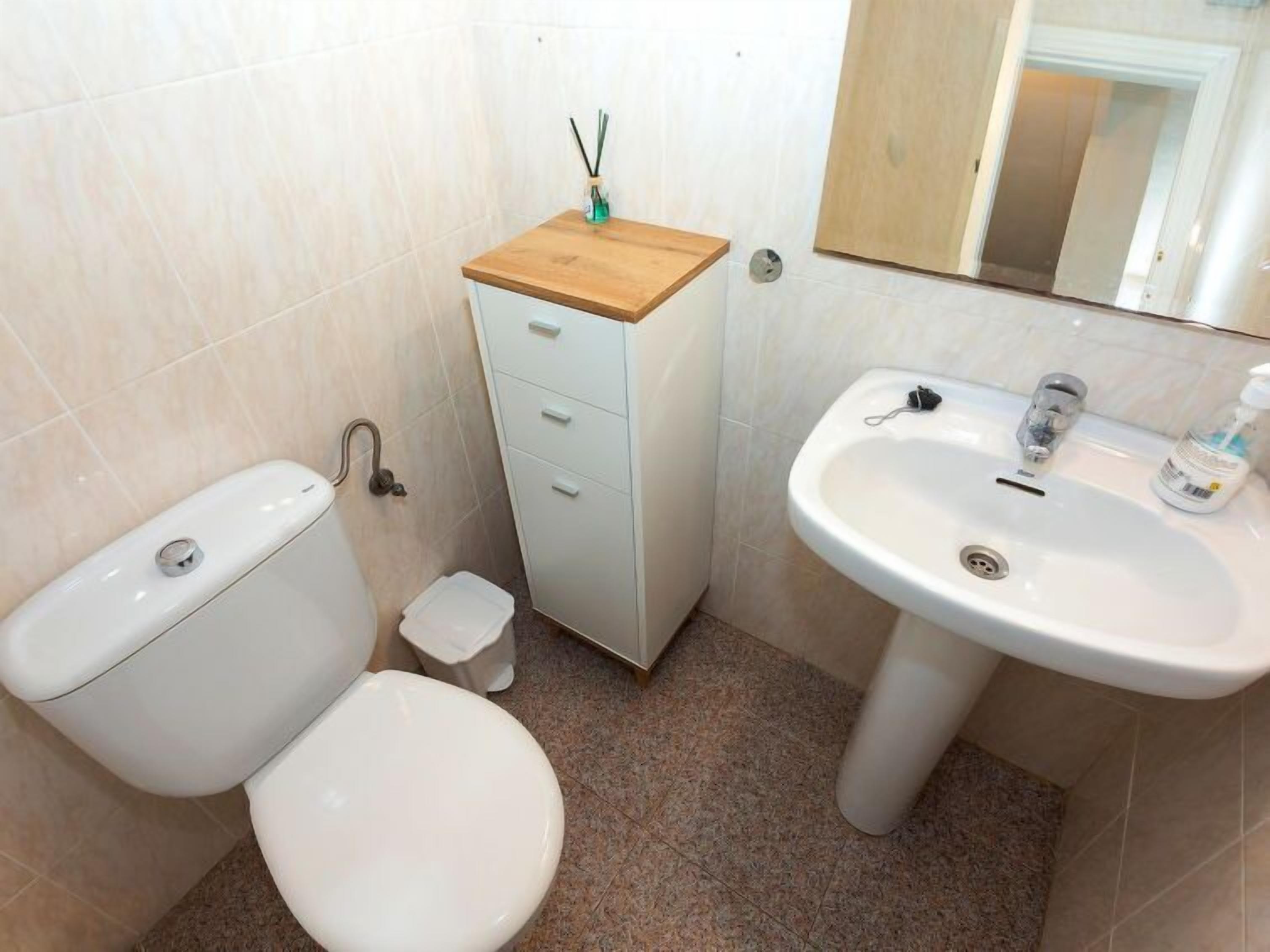 Une petite salle de bain avec des toilettes, un lavabo et un meuble.