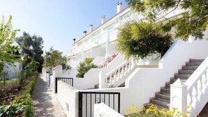 A white building with a staircase leading to a balcony.