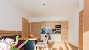 Una cocina moderna con armarios de madera y una zona de comedor con una mesa y sillas de madera.