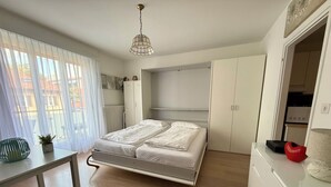 Una camera da letto moderna con un letto, una scrivania e un armadio.