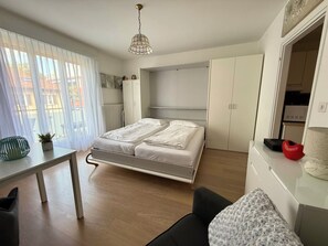 A modern bedroom with a bed, a desk, and a wardrobe.