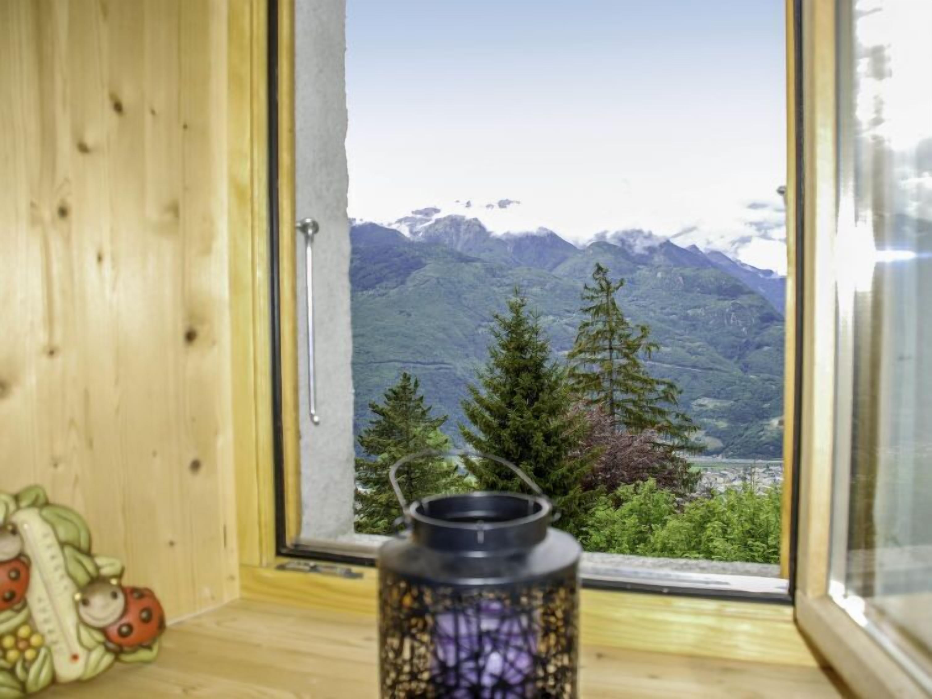 A wooden interior with a window revealing a mountainous landscape.