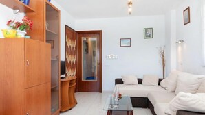 Ein modernes Wohnzimmer mit einer Couch, einem Glastisch und Holzschränken.