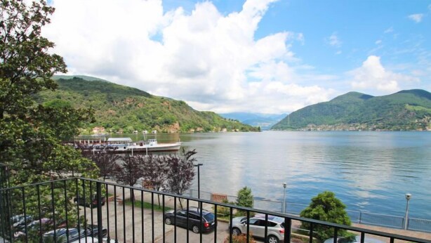 Une vue sur le lac, avec un espace de stationnement, des bateaux et un paysage montagneux.