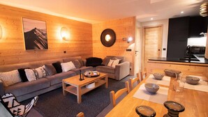 A cozy living room with a sofa, coffee table, and dining area. - 5-room duplex for 10 guests with balcony, Hameau de la Forêt (Valmorel)